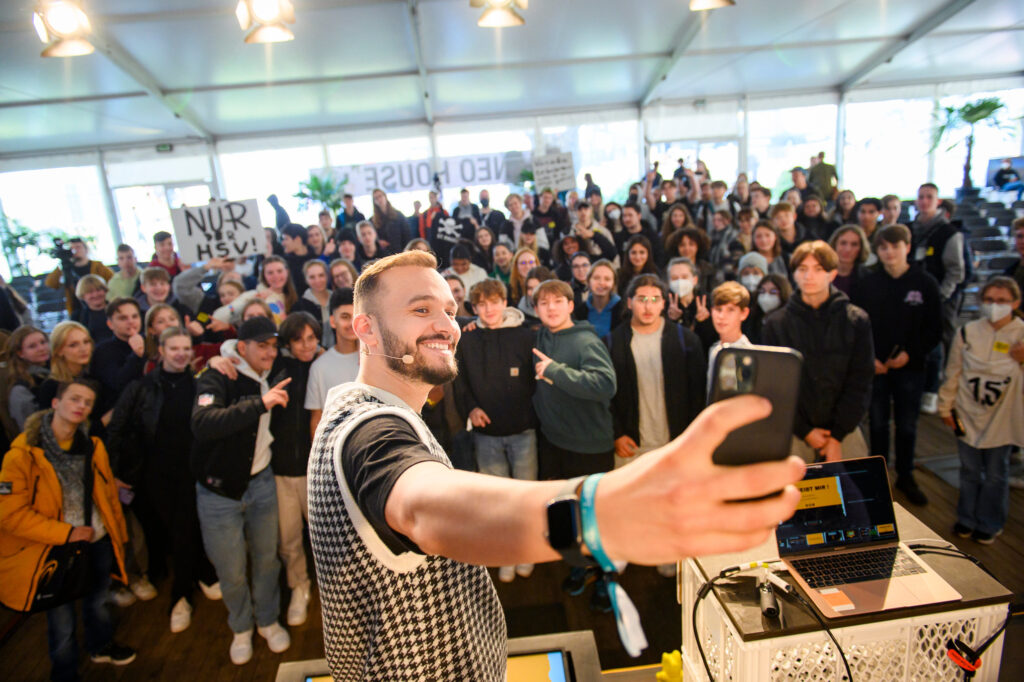 23.09.2022: Marcel Nadim Aburakia mit seinem Talk „WM in Katar - gucken oder nicht?“ während der TINCON auf dem Reeperbahn Festival in Hamburg. – Die TINCON ist die Konferenz für digitale Jugendkultur. Das heißt in Talks, Workshops und Q&As geben Speaker:innen ihr Können und Wissen an das junge Publikum weiter. Die TINCON ist ein geschützter Ort, an dem sich junge Leute von 13 bis 25 Jahren vernetzen, informieren und mit Idolen austauschen können. Ein Event, das sie selbst mitgestalten.  Foto: Jonas Walzberg