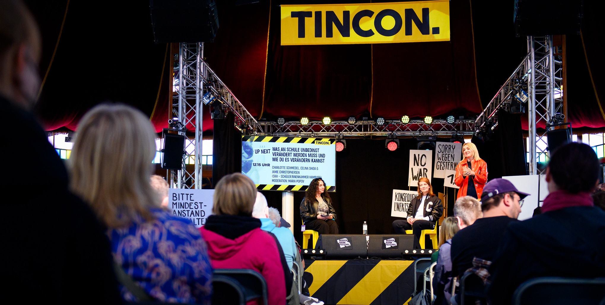 Zwei Junge Frauen unterhalten sich auf der TINCON Bühne mit Linda Zervakis. 