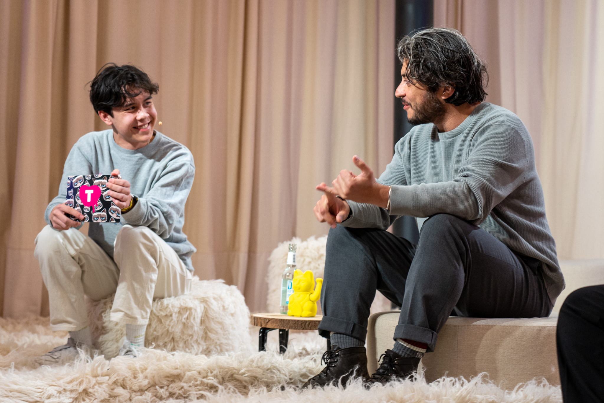 Khesrau Behroz im Interview auf der Bühne. Er wird von einem jungen Moderator befragt. 